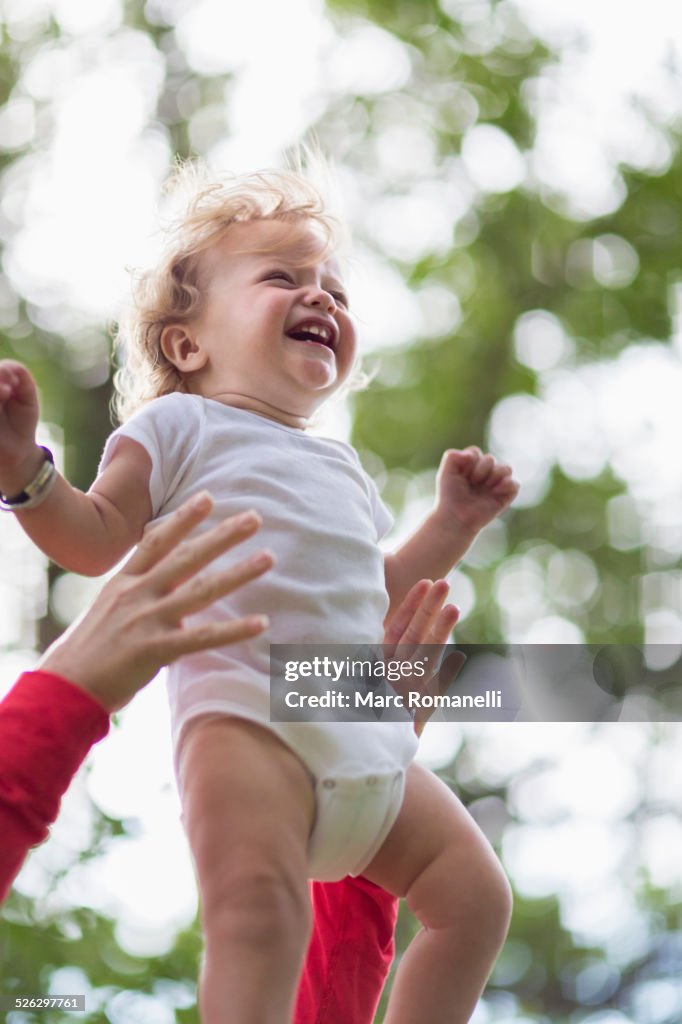 Caucasian mother playing with baby boy outdoors