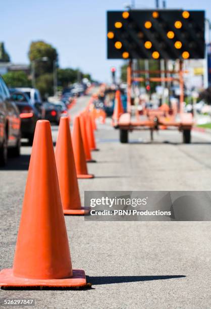 close up of traffic cones on busy street - road works stockfoto's en -beelden