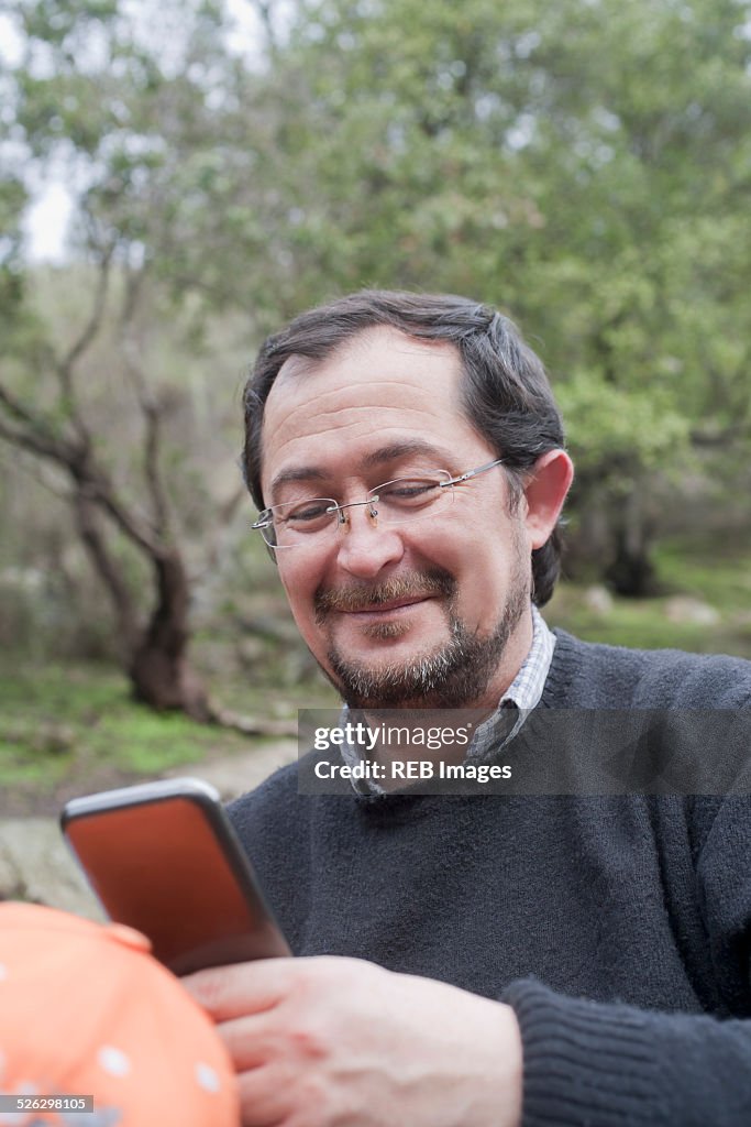 Hispanic man using cell phone in park