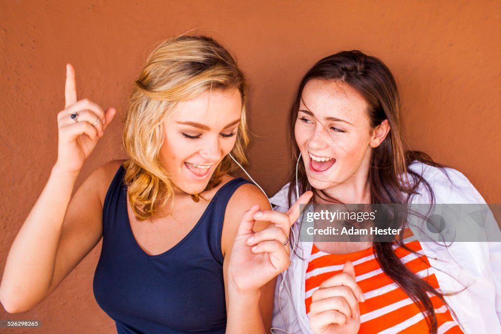 Caucasian teenage girls listening to earbuds