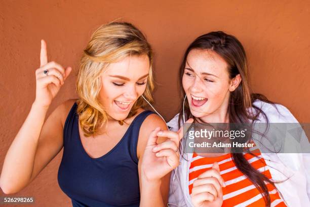 caucasian teenage girls listening to earbuds - girl singing imagens e fotografias de stock