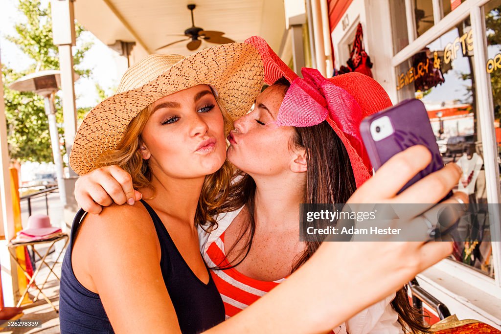 Caucasian teenage girls taking cell phone selfie in hats