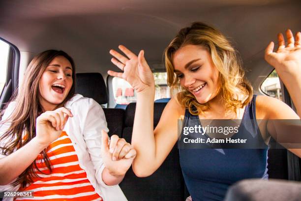 caucasian teenage girls dancing in back seat of car - girl singing imagens e fotografias de stock