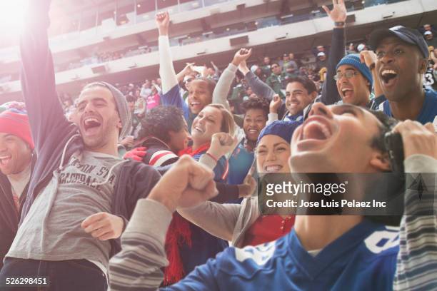 fans cheering at american football game - fan stock-fotos und bilder