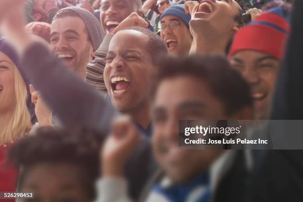 fans cheering at american football game - football ball close up stock pictures, royalty-free photos & images