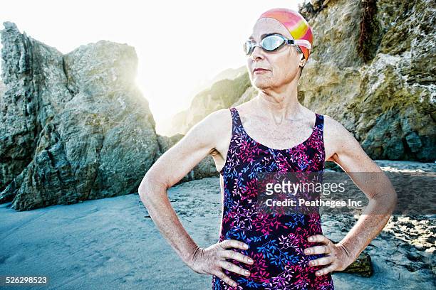 Older Caucasian woman wearing goggles and swimsuit on beach