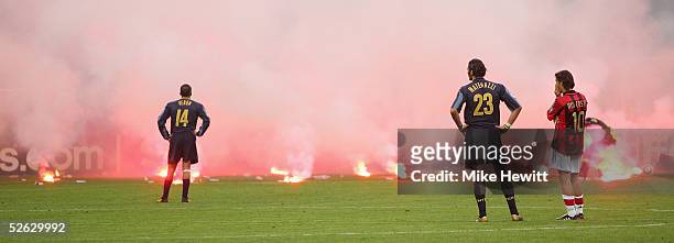 Flares rain down onto the pitch from Inter Milan fans as Juan Sebastian Veron and Marco Materazzi of Inter Milan and Rui Costa of AC Milan look on...
