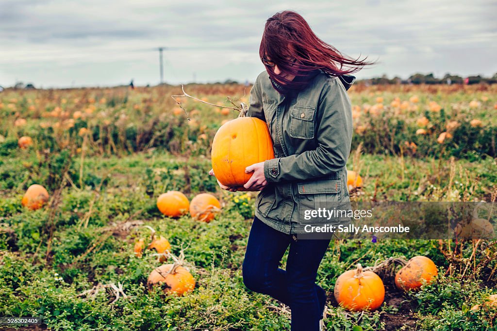 Young woman picking pumpkins