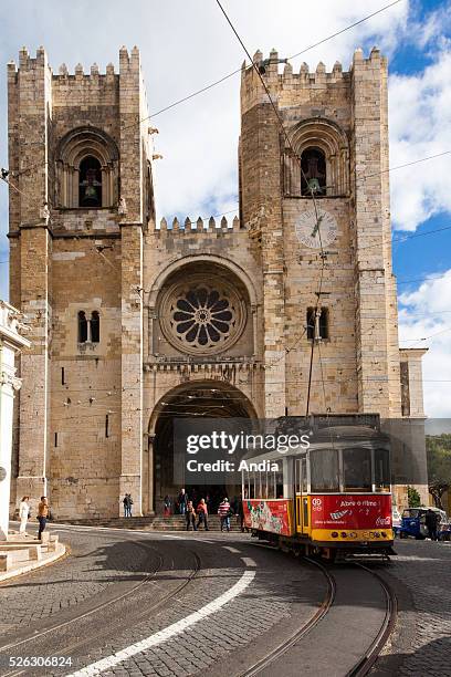 Portugal, Lisbon : an old red tram on line nr. 28 passes by Santa Maria Maior of Lisbon cathedral . It is the oldest church in the city. November...