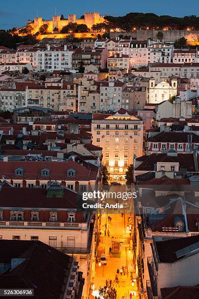 Portugal, Lisbon : Night view on the roofs and a pedestrian street in Baixa district in the foreground. In the background, the city houses with the...
