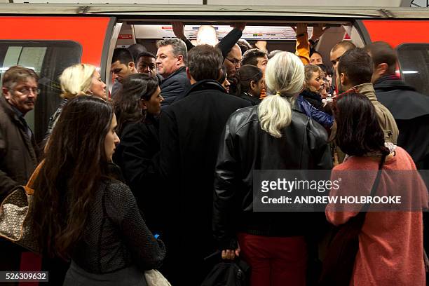 November 17, 2011 - London subway riders struggle to get on a crowded subway car at rush hour on the Central Line.