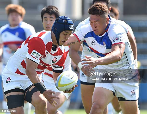 Japan's flanker Taiyo Ando and South Korea's number eight Han Kun Kyu chase the ball during their Asian Rugby Championship rugby match in Yokohama on...