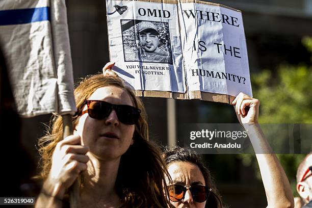 Protestor holds a banner of 23-year-old Iranian known as Omid, an Iranian refugee who set himself on fire at the Nauru detention centre and died in a...