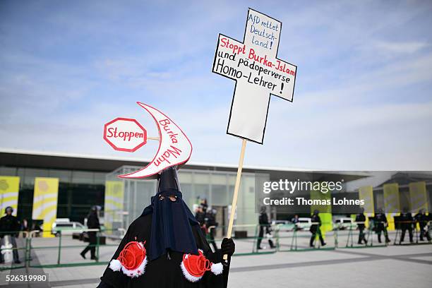 Demonstrator dressed up in a 'burka' protests against AfD the Alternative fuer Deutschland political party federal congress on April 30, 2016 in...