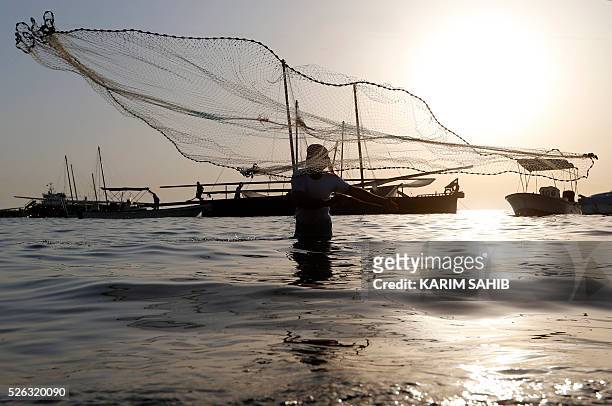 An Emirati fisherman throws his net on al-Mirfa beach, outside Abu Dhabi on April 30, 2016 during the al-Gharbia Watersports festival. / AFP / KARIM...