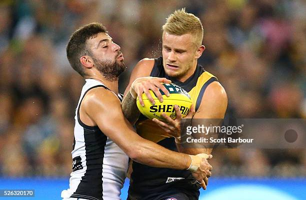 Brandon Ellis of the Tigers is tackled by Jimmy Toumpas of the Power during the round six AFL match between the Richmond Tigers and the Port Adelaide...