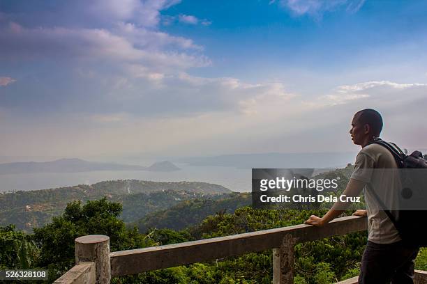 backpacker holding on a rail looking over the scenery - tagaytay stock pictures, royalty-free photos & images