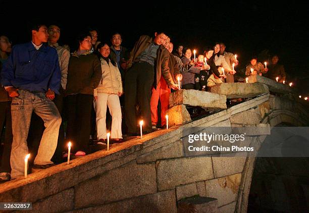 Chinese people light candles to mourn late Chinese artist Chen Yifei during a condolence ceremony on April 14, 2005 at Zhouzhuang Town in Kunshan of...