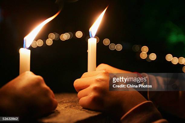 Chinese people light candles to mourn late Chinese artist Chen Yifei during a condolence ceremony on April 14, 2005 at Zhouzhuang Town in Kunshan of...