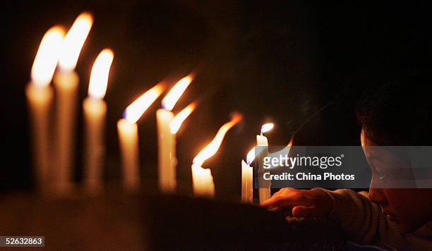 Chinese people light candles to mourn late Chinese artist Chen Yifei during a condolence ceremony on April 14, 2005 at Zhouzhuang Town in Kunshan of...