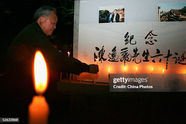 Chinese man lights a candle to mourn late artist Chen Yifei during a condolence ceremony on April 14, 2005 at Zhouzhuang Town in Kunshan of Jiangsu...