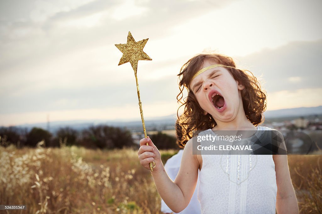 Girl holding a magic wand yawning