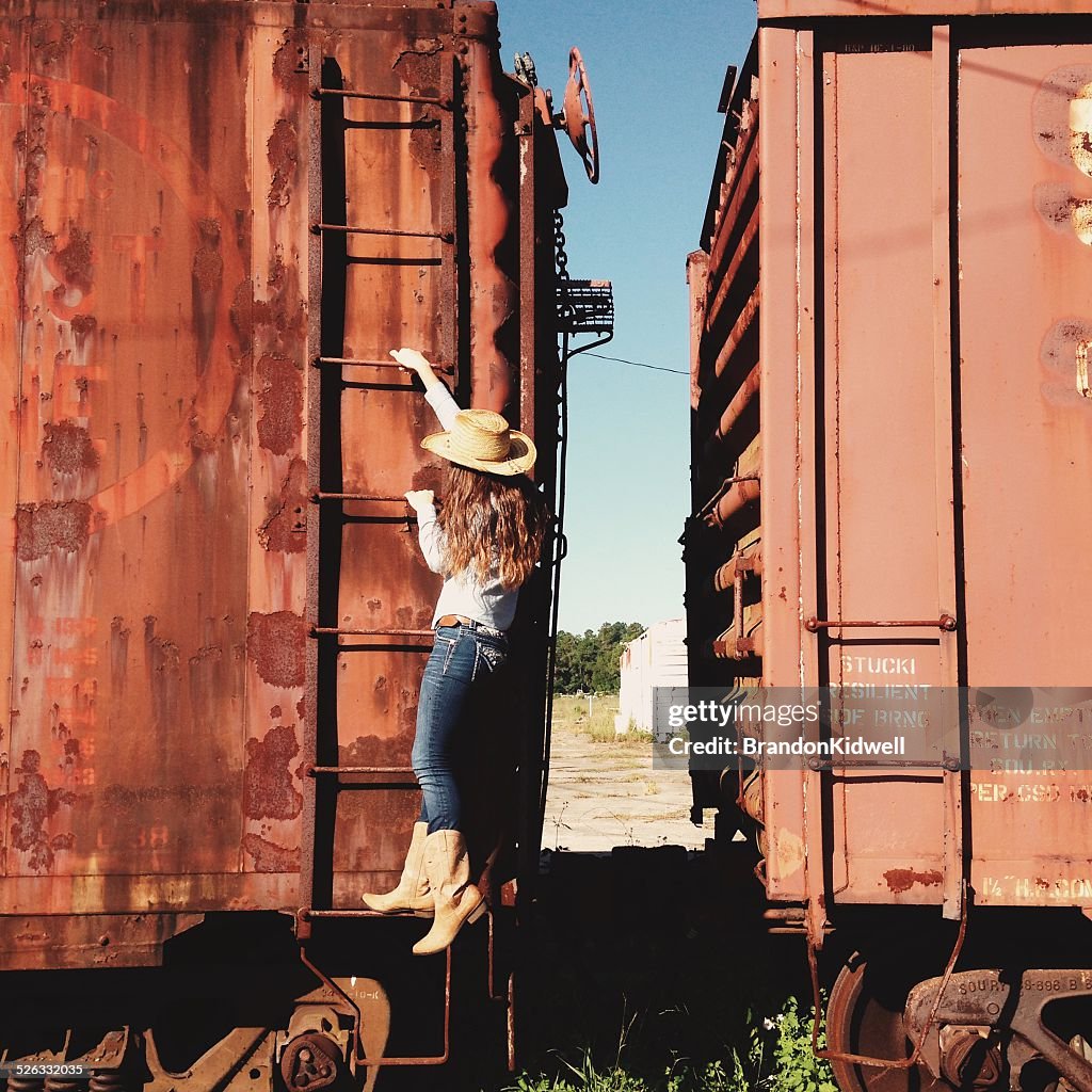 Cowgirl climbing an abandoned train