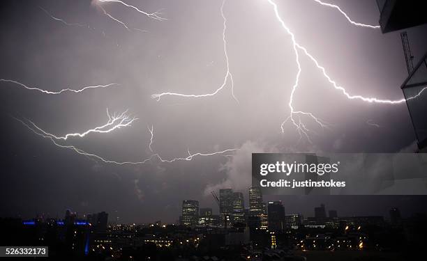 uk, london, thunder and lightening above canary wharf - thunderstorm uk stock pictures, royalty-free photos & images