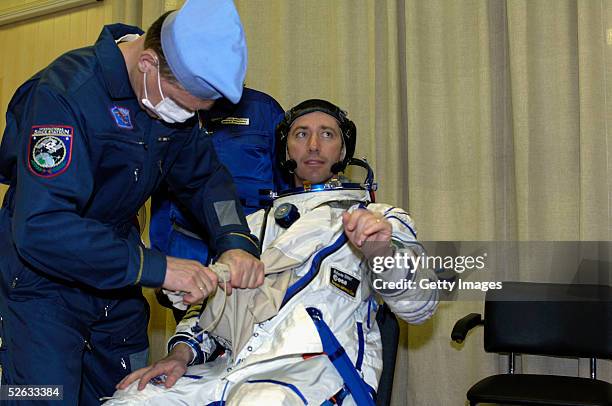 The Eneide crew make final checks of their Sokol pressure suit before lift off in the MIK preparation facility at the Baikonur cosmodrome on April...