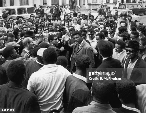 Heavyweight boxing champion Cassius Clay surrounded by fans and photographers during a visit to the London Free School children's play group and...