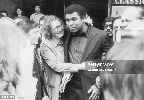 Heavyweight boxing champion Muhammad Ali receives an early birthday greeting from TV technician Maureen White as he leaves the Classic cinema in...