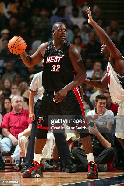 Shaquille O'Neal#32 of the Miami Heat looks to pass the ball against Emeka Okafor#30 of the Charlotte Bobcats at Charlotte Coliseum on March 26, 2005...