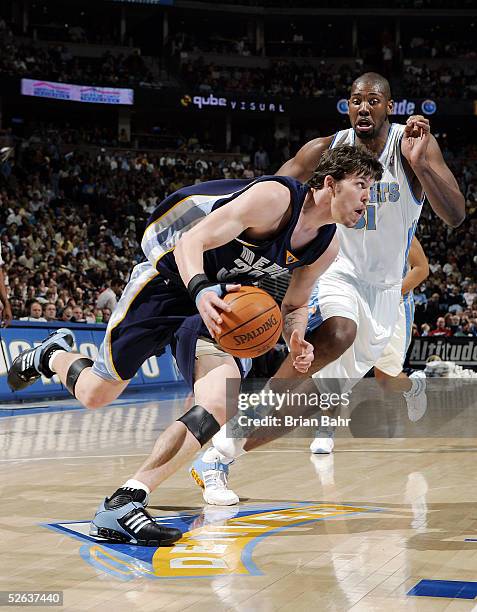 Mike Miller of the Memphis Grizzlies drives for the net past Nene of the Denver Nuggets in the second half on April 15, 2005 at the Pepsi Center in...