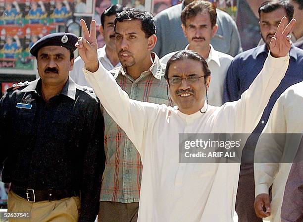 Asif Ali Zardari, the husband of former Pakistani premier Benazir Bhutto, flashes the victory sign outside his residence in Lahore 16 April 2005,...