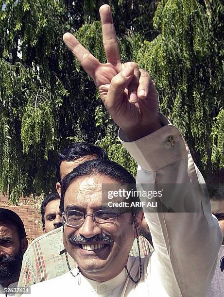 Asif Ali Zardari, the husband of former Pakistani premier Benazir Bhutto, flashes the victory sign outside his residence in Lahore 16 April 2005,...