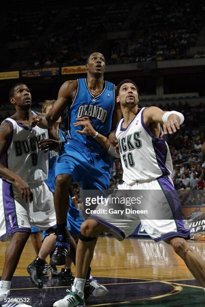Dwight Howard of the Orlando Magic battles for a rebound with Dan Gadzuric and Joe Smith of the Milwaukee Bucks during the NBA game at the Bradley...