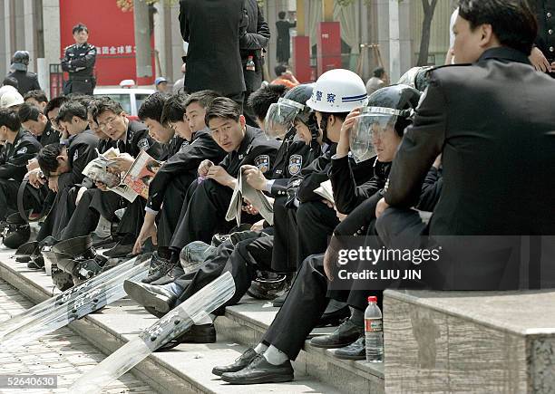 Chinese policemen rest on the steps near the Japanese consulate in Shanghai, 17 April 2005. East Asia's two most powerful nations faced one of their...