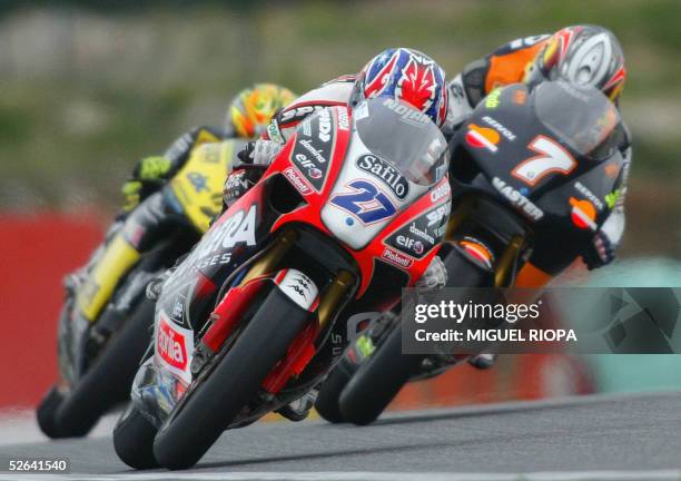 Casey Stoner of Australia rides his Aprilia next to French Randy de Puniet and Italian Andrea Dovizioso during the 250cc race of the Portuguese Grand...