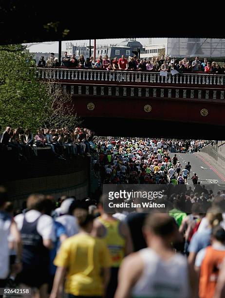 Spectators cheer on runners during the Flora London Marathon 25th Anniversary Race at Blackfriars on March 17, 2005 in London, England.