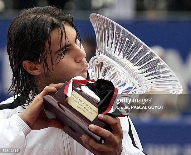 Spain's Rafael Nadal kisses his trophy, decorated with a black ribbon in memory of late Monaco's Prince Rainer III who died last 06 April, after...