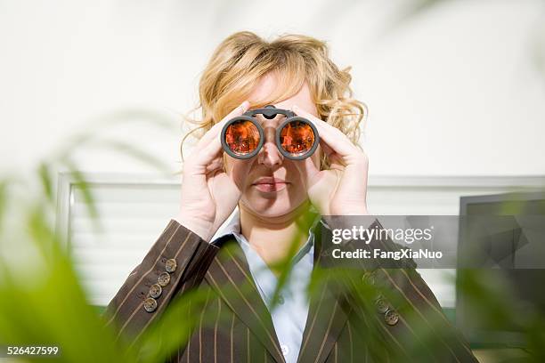 frau blick durchs fernglas im büro - private view stock-fotos und bilder