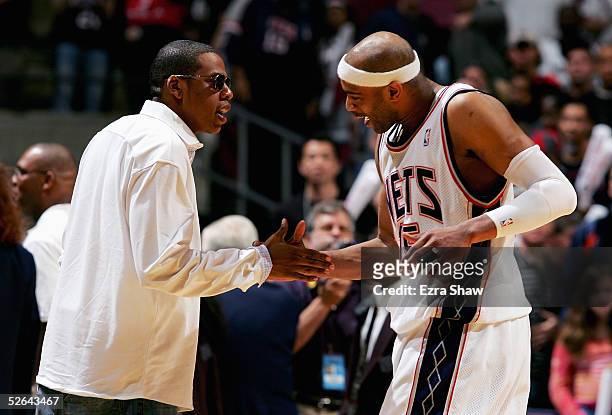 Vince Carter of the New Jersey Nets shakes hands with Jay-Z after they beat the Philadelphia 76ers on April 17, 2005 at Continental Airlines Arena in...