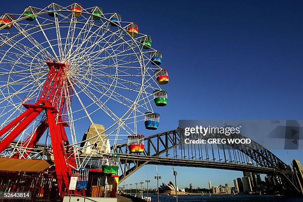 Ferris wheel at Luna Park, appears to tower over the Sydney Harbour Bridge in this photo taken 10 April 2005, as it links the northern and southern...