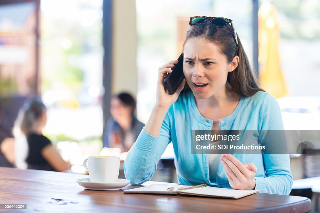 Woman making angry phone call in local coffee shop
