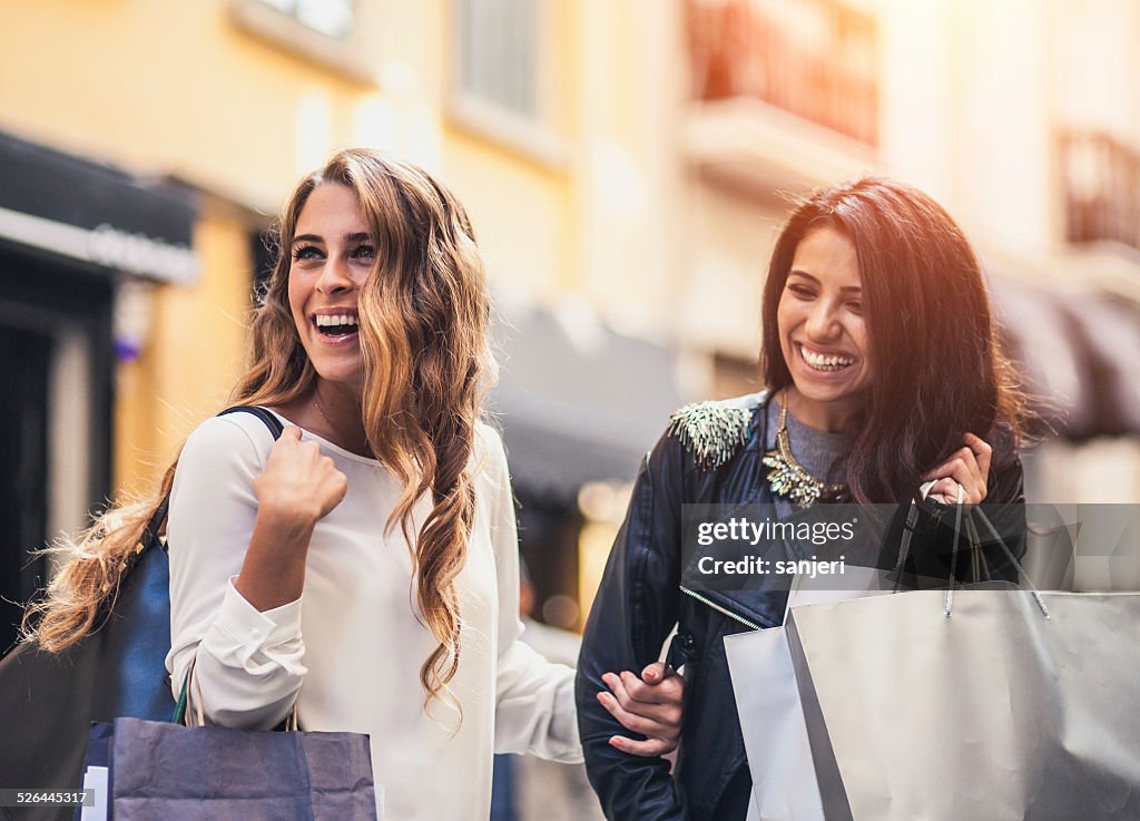 Zwei Freunde ont der Straße mit Einkaufstaschen