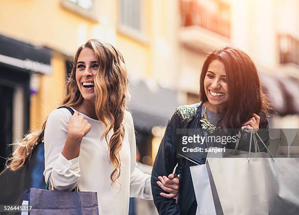 two friends ont the street with shopping bags - downtown shopping stock pictures, royalty-free photos & images