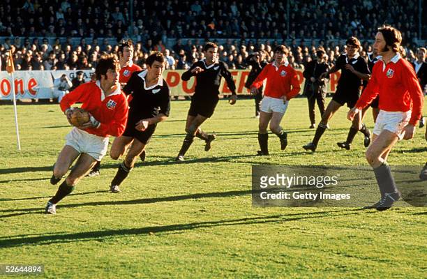 Barry John of the British Lions is pursued by Tane Norton of New Zealand during the First Test match between New Zealand and the British Lions at...