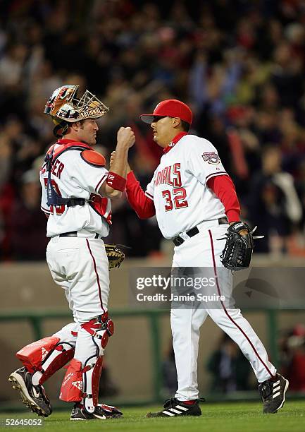 Chad Cordero and Brian Schneider of the Washington Nationals celebrate the teams first ever home win against the Arizona Diamondbacks during the...