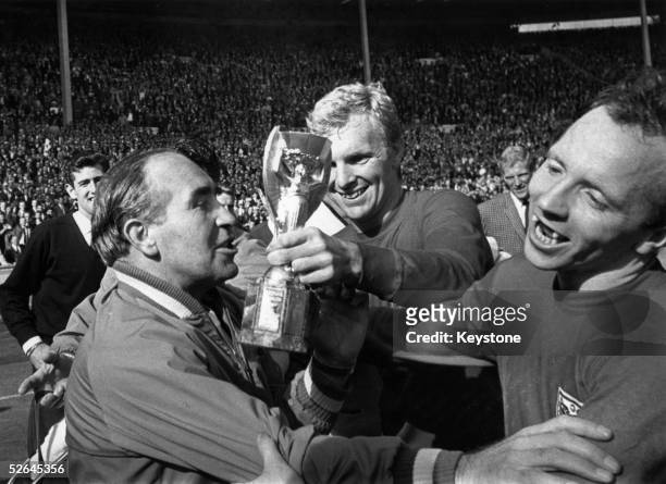 England Manager Alf Ramsey celebrates his team's 4-2 victory in extra time over West Germany in the World Cup Final at Wembley Stadium. With him is...