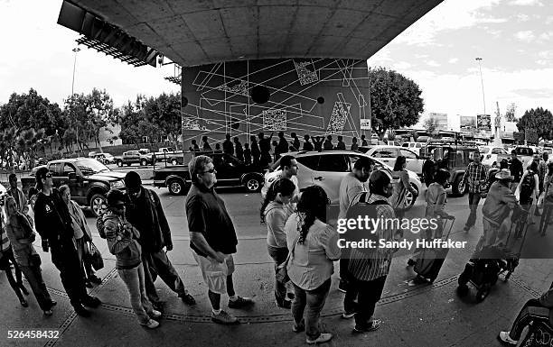 Pedestrians wait in line to cross the U.S.-Mexico border in Tijuana, Mexico on Sunday, March 3, 2013. Due to the recent Sequestration cuts, Customs...